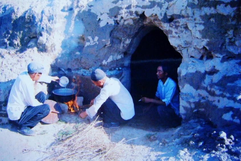 1983年，“六老漢”一代治沙人在“地窩子”生活做飯。新華社發(fā)（八步沙林場供圖）