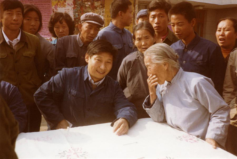 1983年，時(shí)任河北正定縣委書記的習(xí)近平（前排居中），臨時(shí)在大街上擺桌子聽取老百姓意見。